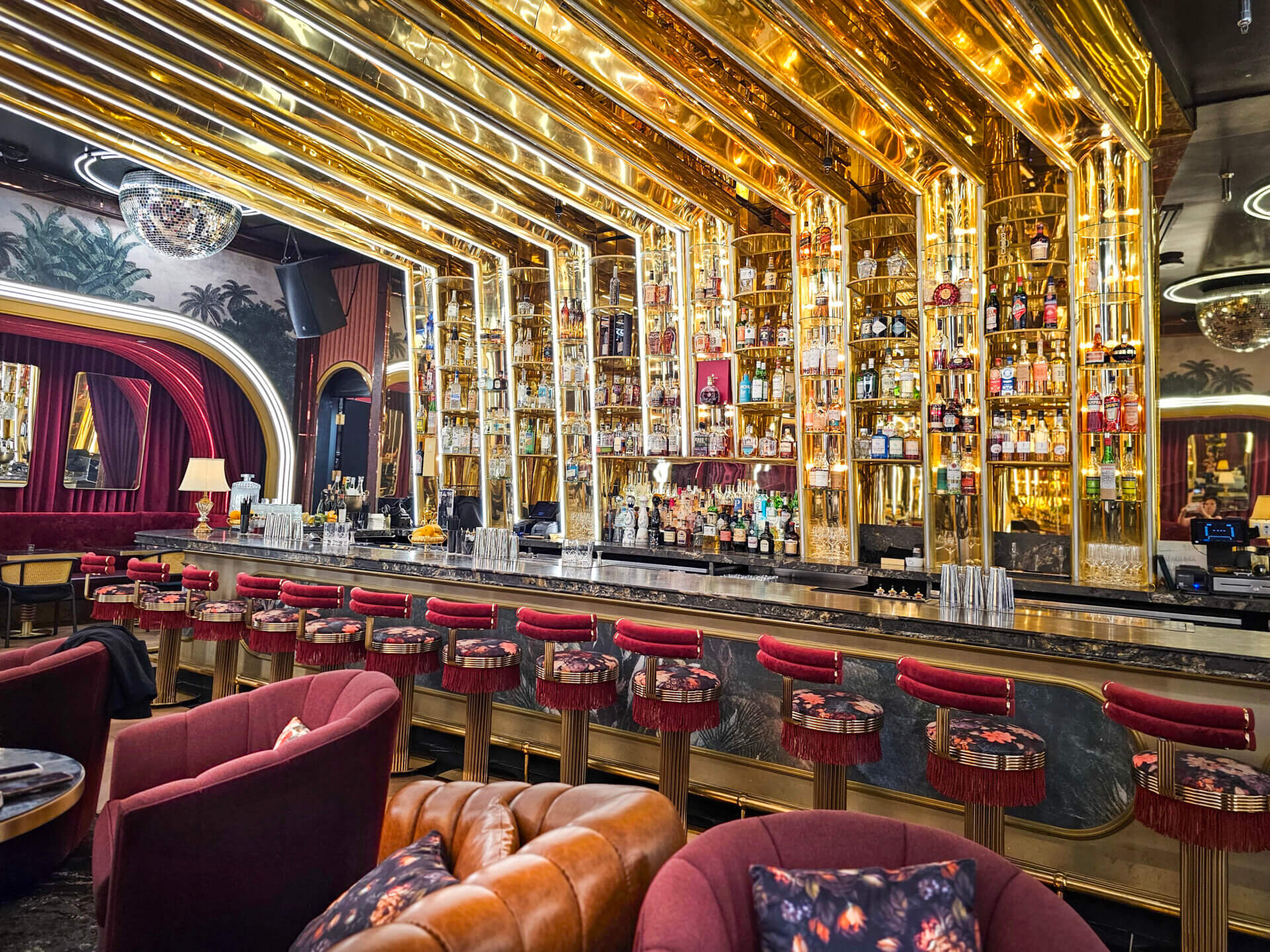 Opulent bar interior with gold accents, velvet seating, and disco ball at a premium entertainment venue